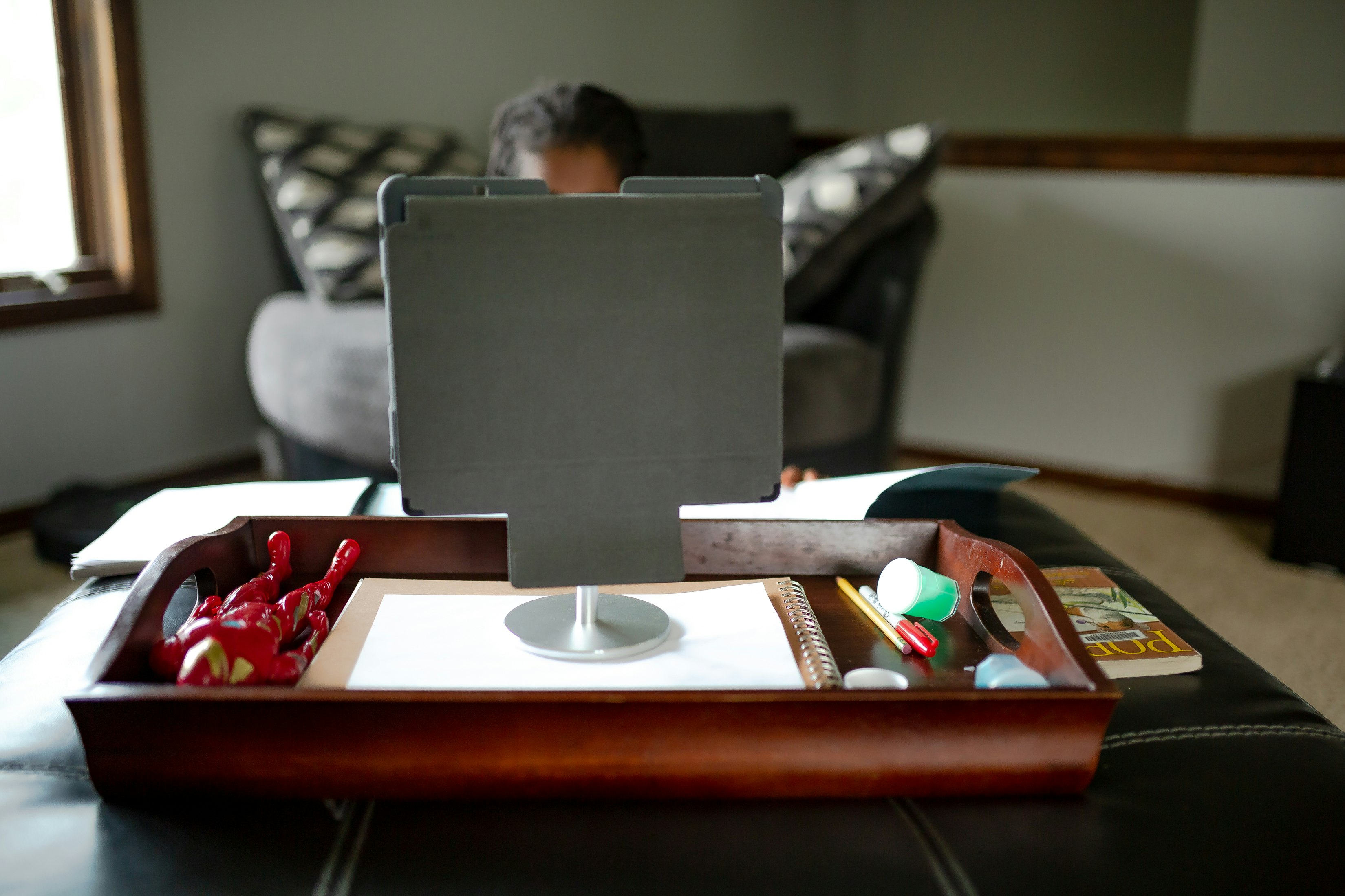 boy in red shirt sitting on chair in front of black laptop computer